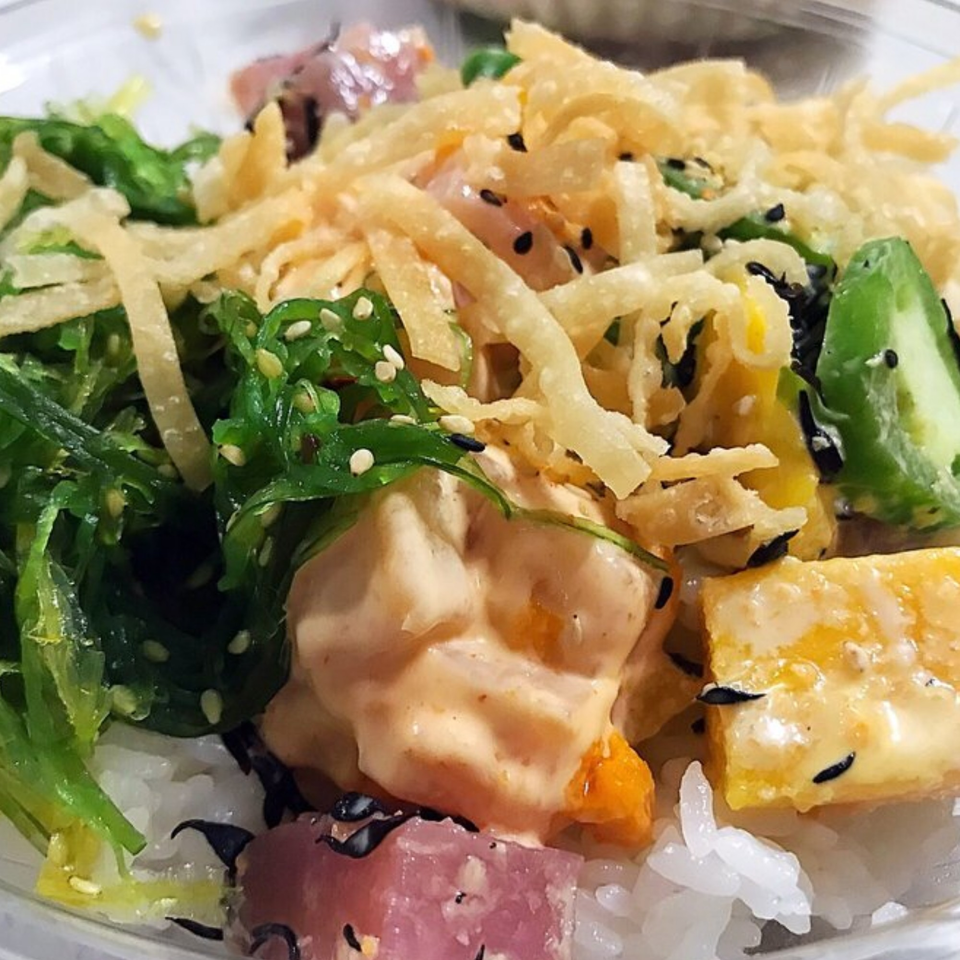 Close-up of a vibrant Poke Ice poke bowl with fresh ingredients and crispy toppings.